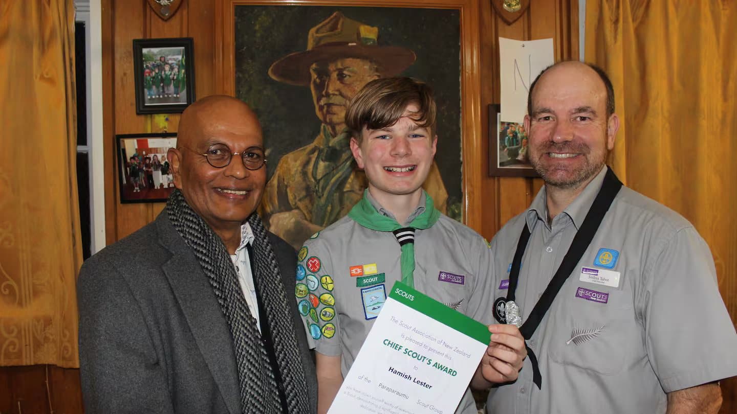 Hamish holding his Chief Scout's Award certificate between two Scout leaders